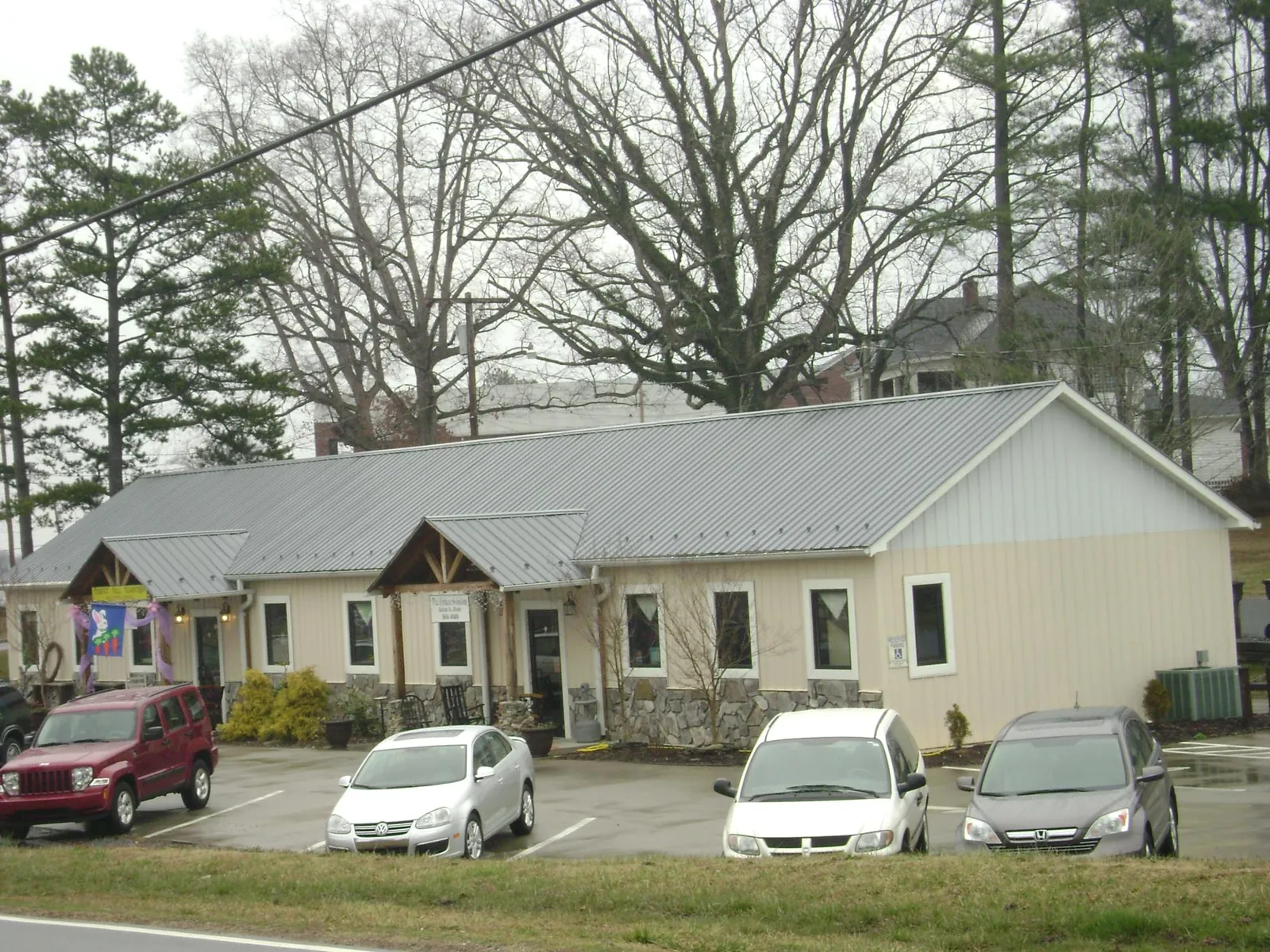 Gray metal roof with timber entry brackets on a small commercial building in Millican