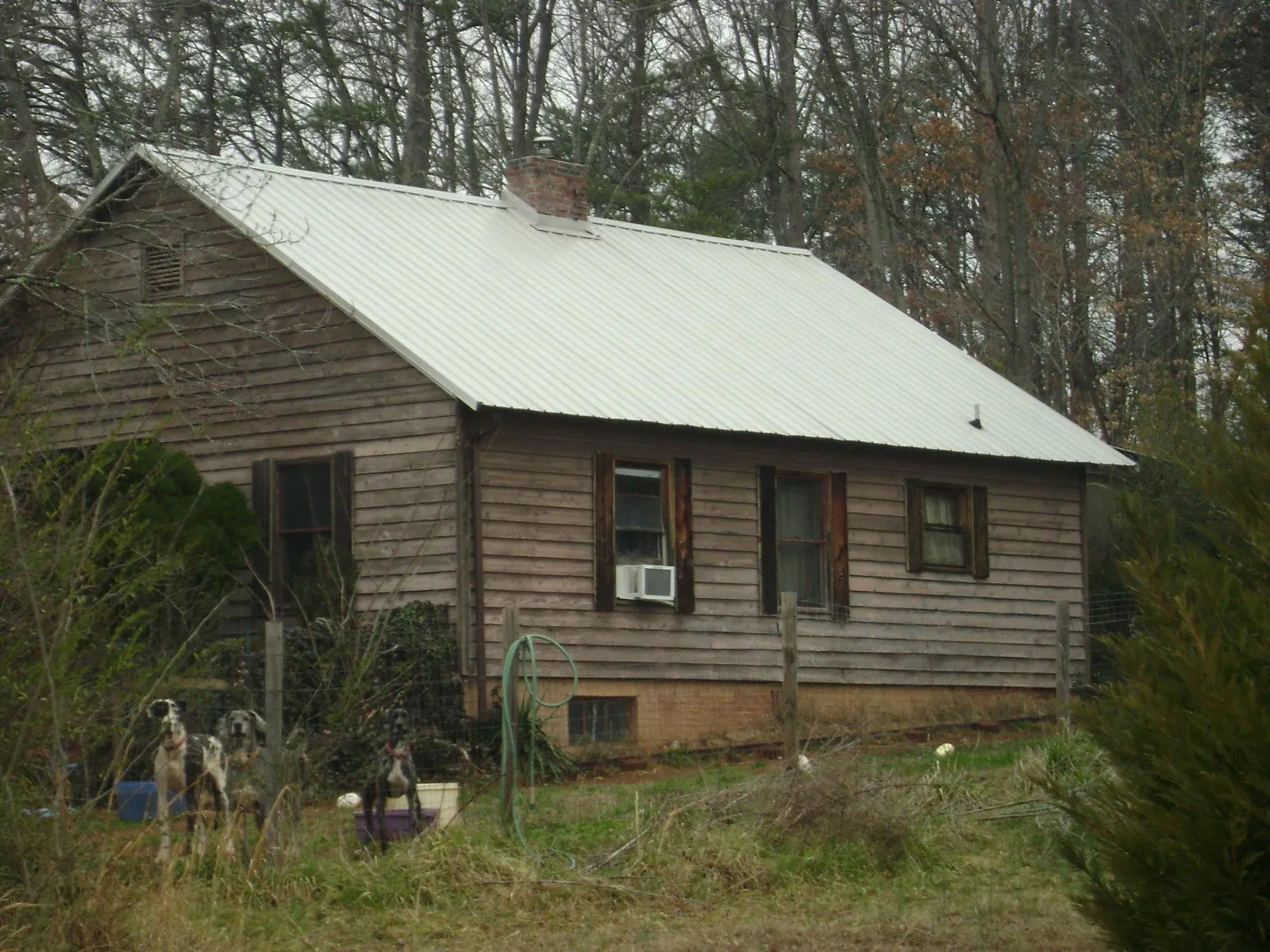 White metal roof on an old wood sided farmhouse, from a Metal Roof Installation job in Millican